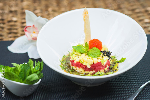 Elegant salad Tartar with herring, avocado, lettuce, restaurant photo