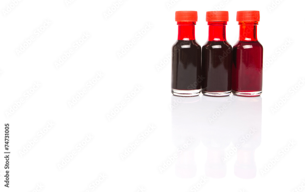 Liquid deep red food color additive over white background Liquid deep red food color additive over white background