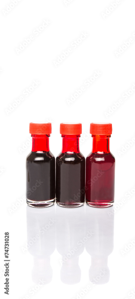 Liquid deep red food color additive over white background Liquid deep red food color additive over white background