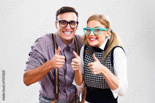 Happy nerdy couple showing thumbs up photo