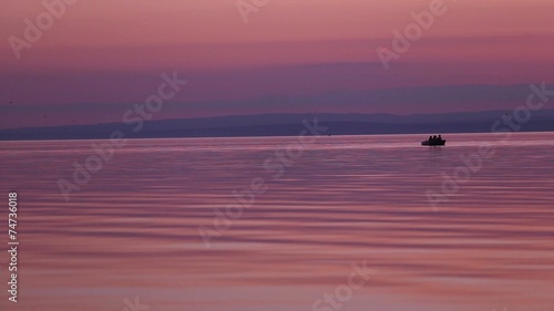 children on a boat on a lake sunset have fun in silhouette