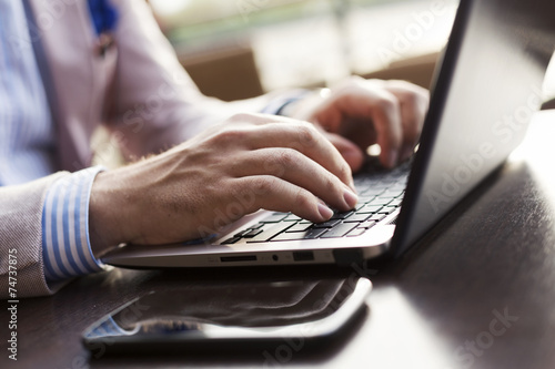 Young businessman typing on laptop