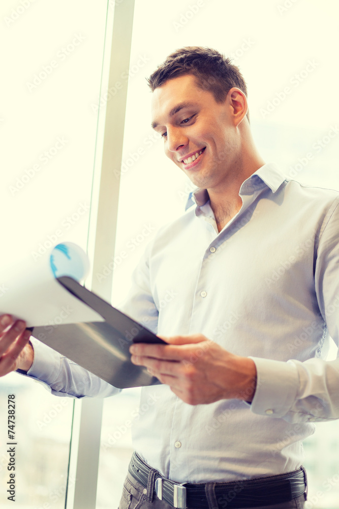 smiling businessman with clipboard in office smiling businessman with clipboard in office