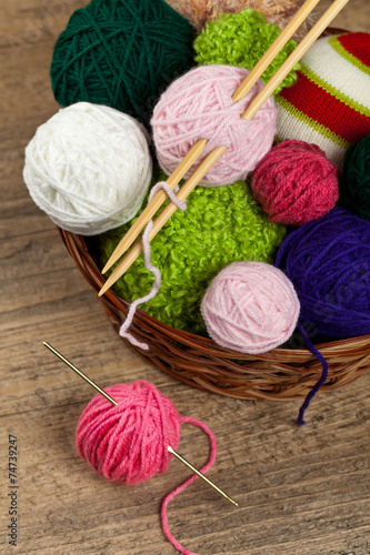Colorful yarn balls in wicker basket. Selective focus.