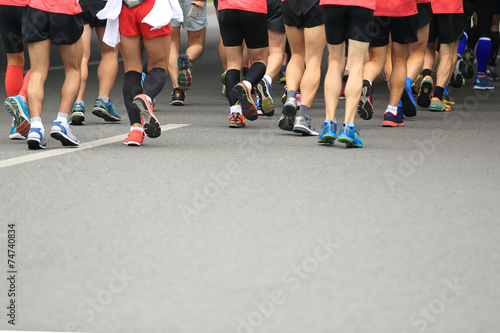 marathon runner legs running on city street © lzf