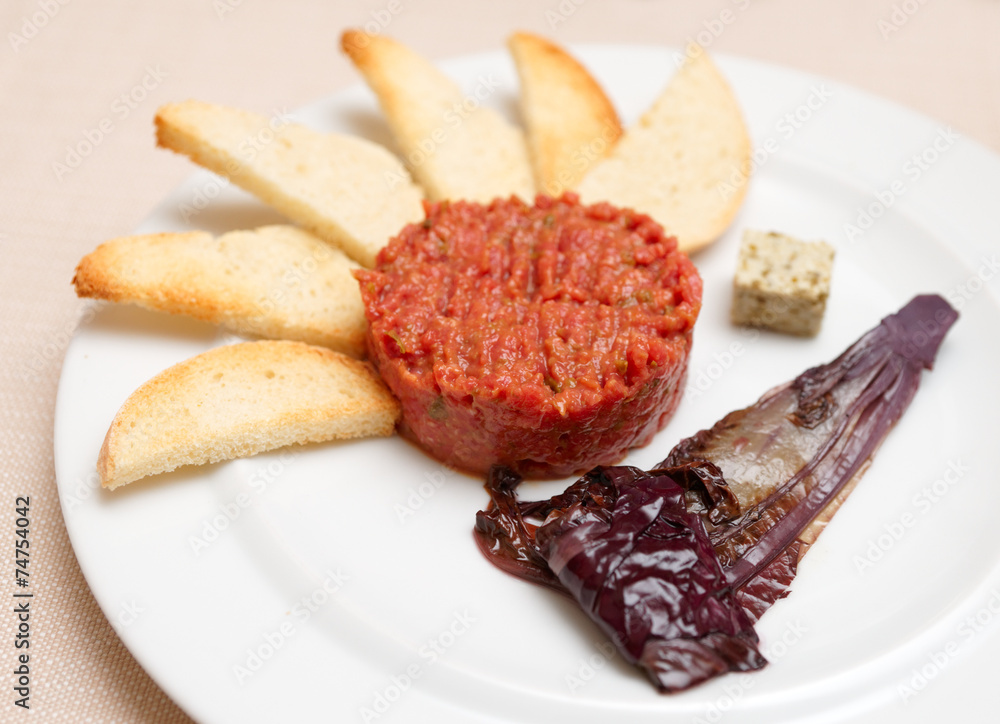 Tartare with toasts and chicory cooked in wine