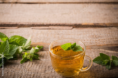 cups of tea with mint on wooden