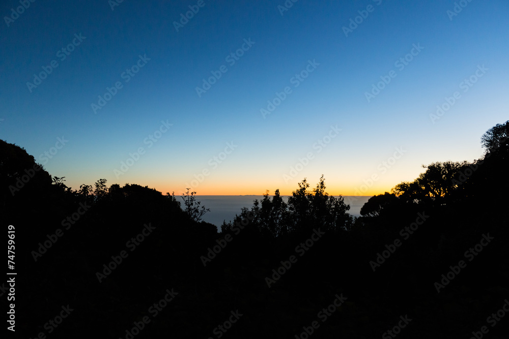 Obraz premium Silhouette atop a mountain with the sunrise.
