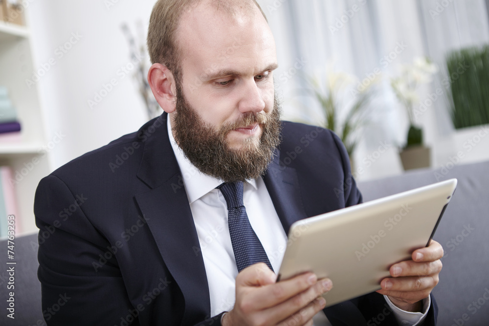Geschäftsmann liest etwas auf seinem Tablet Computer