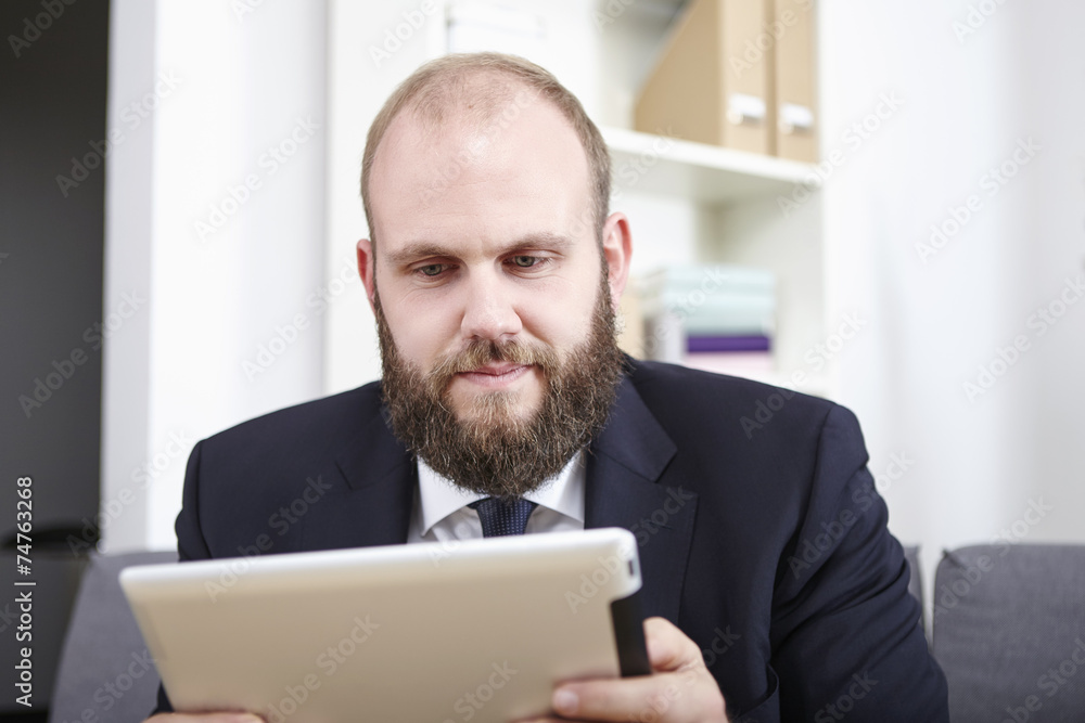 Geschäftsmann liest etwas auf seinem Tablet Computer Geschäftsmann liest etwas auf seinem Tablet Computer