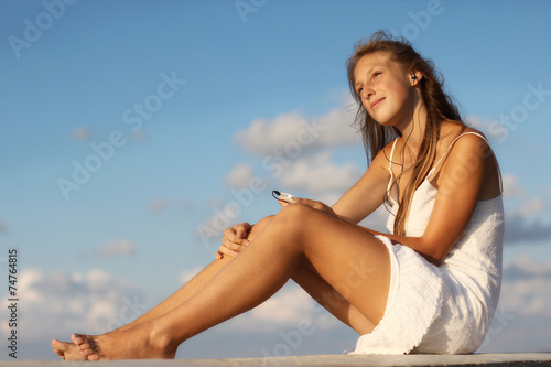 girl with a smartphone resting on the beach