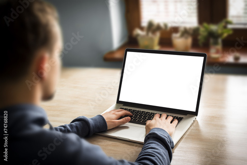 Man using notebook with blank screen, in home interior. photo