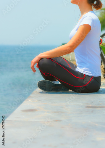 Girl sitting at seaside and relaxing, woman fitness