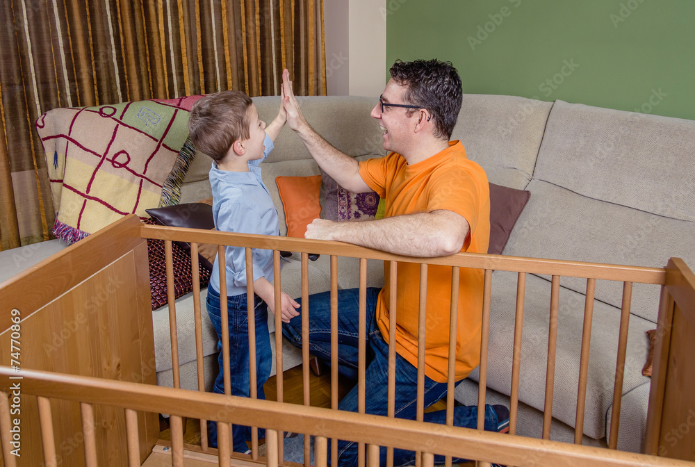 Father and son giving five for success in a home work Father and son giving five for success in a home work
