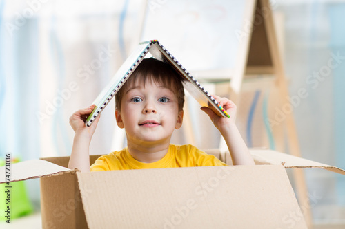 kid boy playing in a toy house