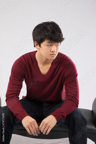 Asian man sitting thoughtfully