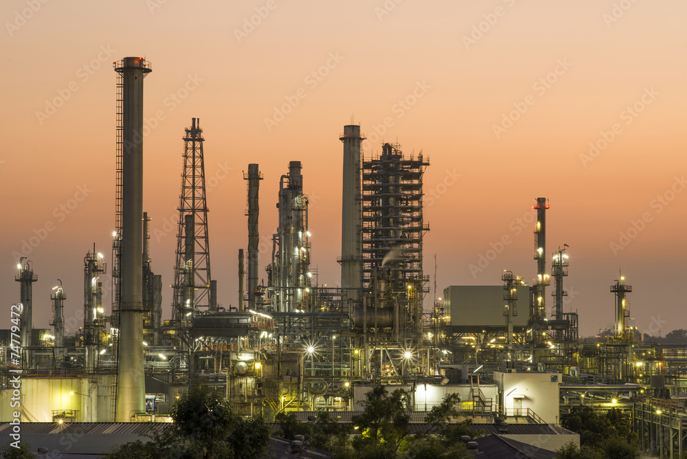 Obraz premium Oil refinery plant at sunset, The night view of petroleum and petrochemical factory with distillation column, drum and pipeline. Gas, diesel and chemical business industry is important for economy.