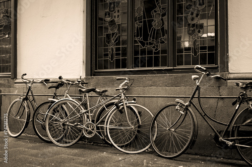 Bicycles leaning against old wall in sepia © dmussman