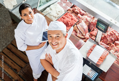 Happy Butchers Standing At Butchery Counter