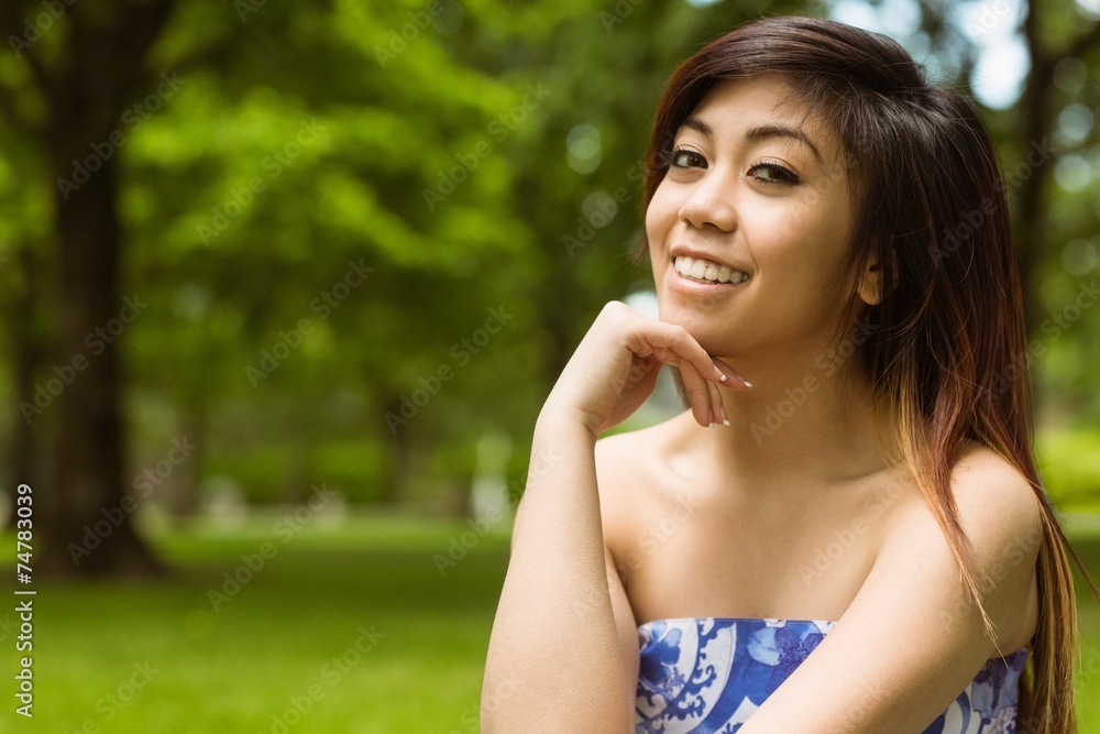 Beautiful woman with hand on chin in park Beautiful woman with hand on chin in park