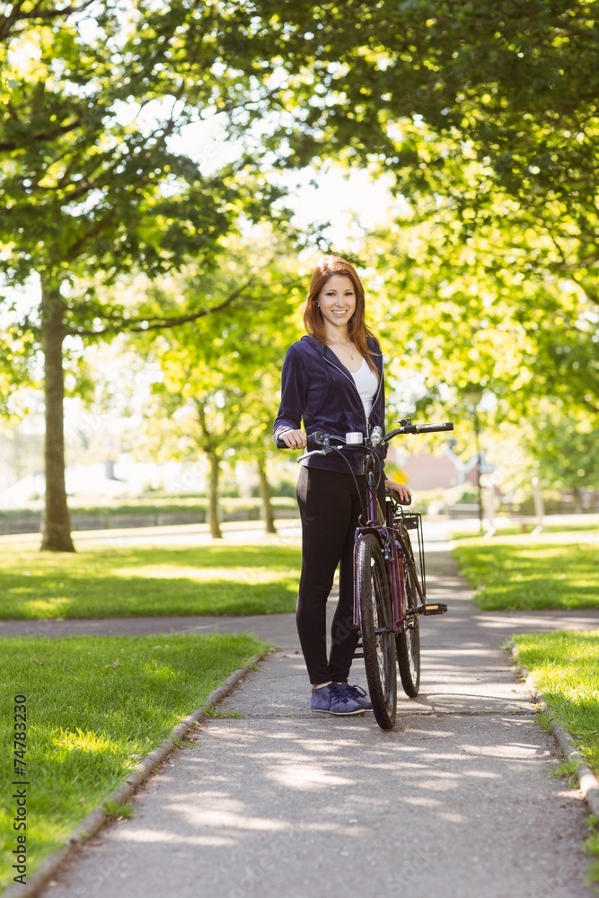 Fototapeta premium Pretty redhead with her bike