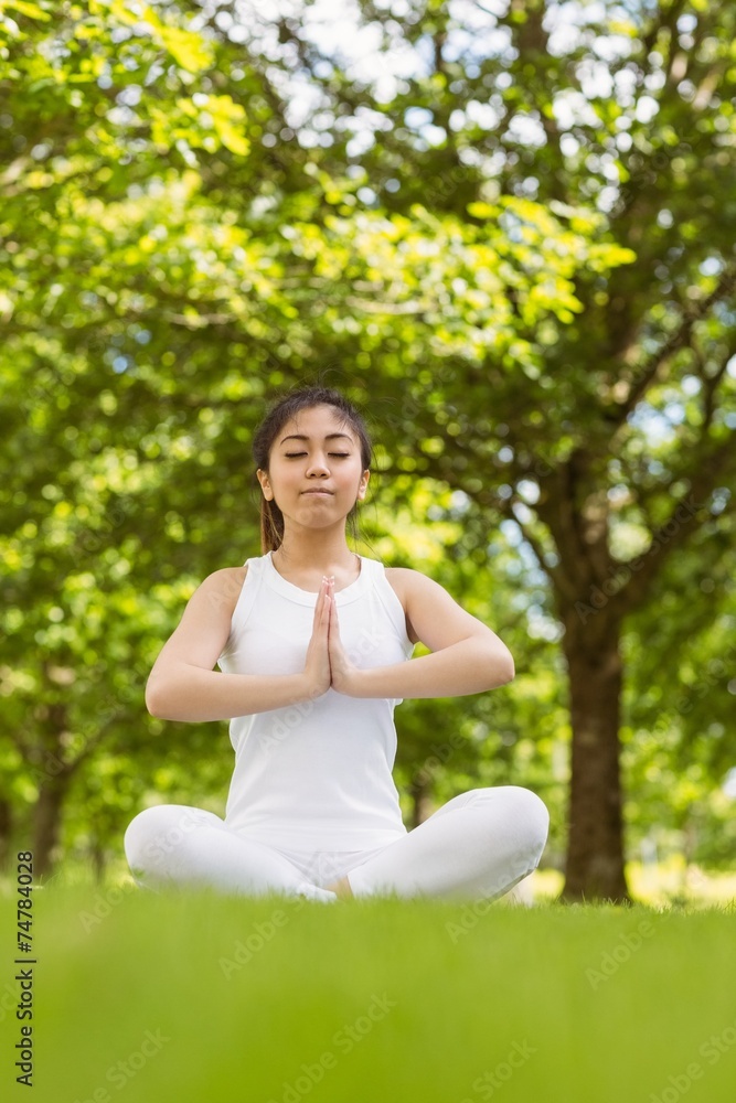 Healthy woman sitting with joined hands at park Healthy woman sitting with joined hands at park