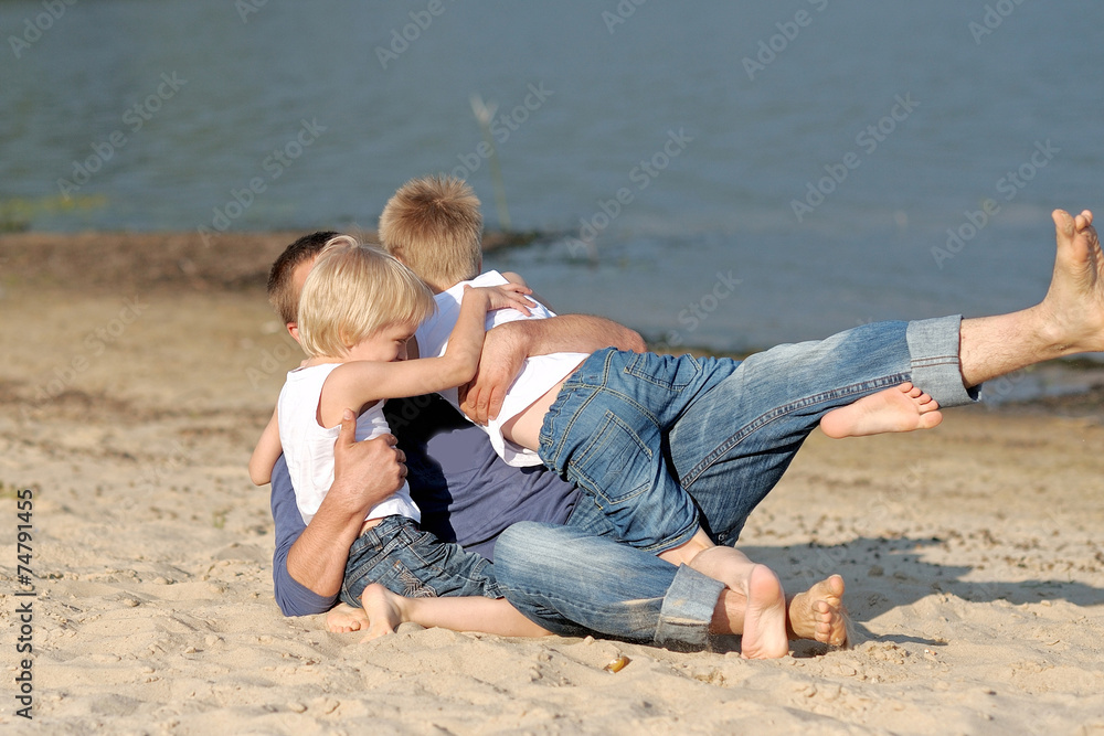 portrait of a father and two sons on the beach portrait of a father and two sons on the beach