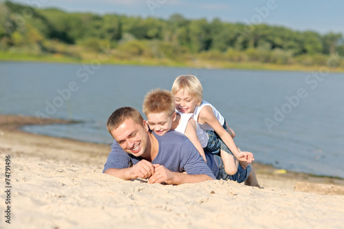 portrait of a father and two sons on the beach