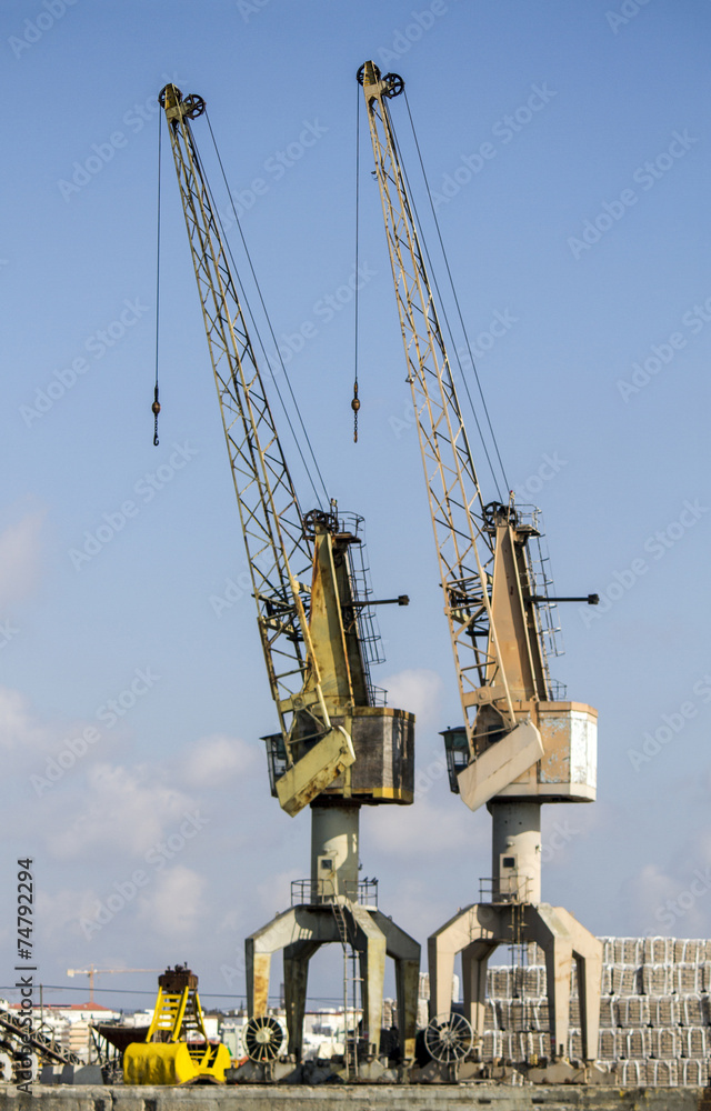 View of silhouettes of crane towers in the docks. View of silhouettes of crane towers in the docks.
