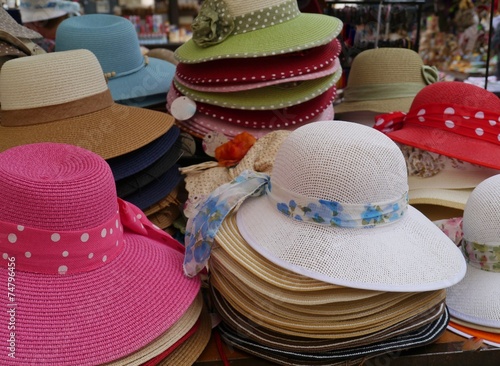 Colorful straw hats with ribbons on a market