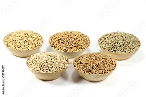 Getreidekörner in Holzschälchen isoliert auf weißem Hintergrund