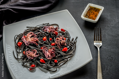 Pasta with black cuttlefish ink and small octopuses