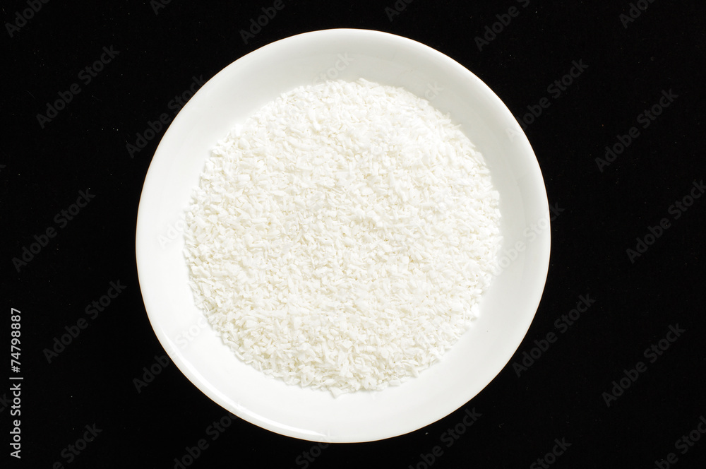 Shredded coconut in the white bowl isolated Shredded coconut in the white bowl isolated