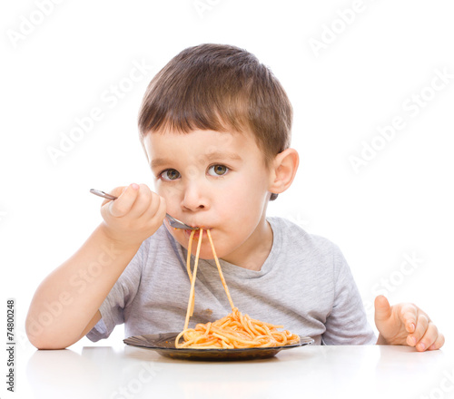 Little boy is eating spaghetti