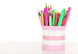 Colorful pens,pencils and markers in striped plastic cup