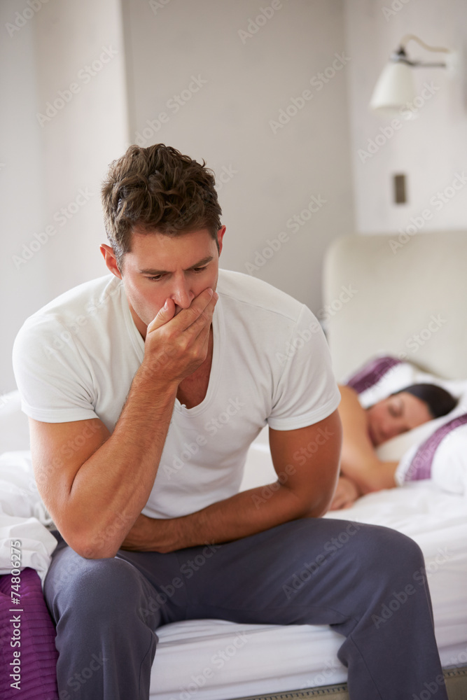 Man Sitting On Bed And Feeling Unwell