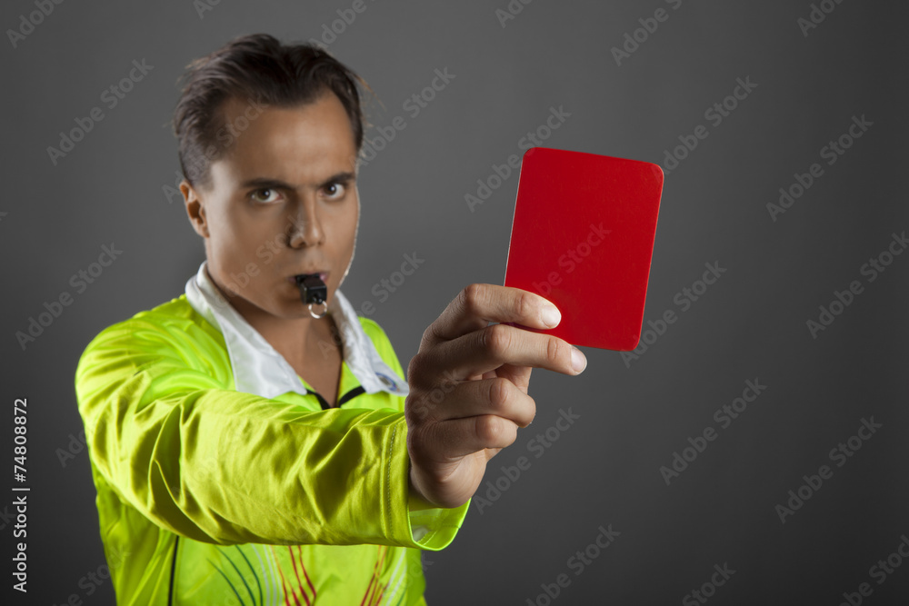 Soccer referee showing the red card isolated on gray background Soccer referee showing the red card isolated on gray background