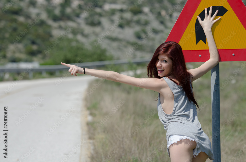 Hot young woman hide a traffic sign danger turn