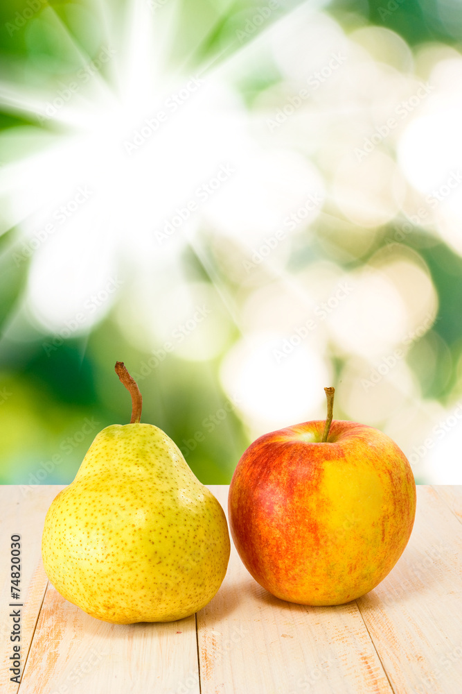image of an apple and pear on sun background