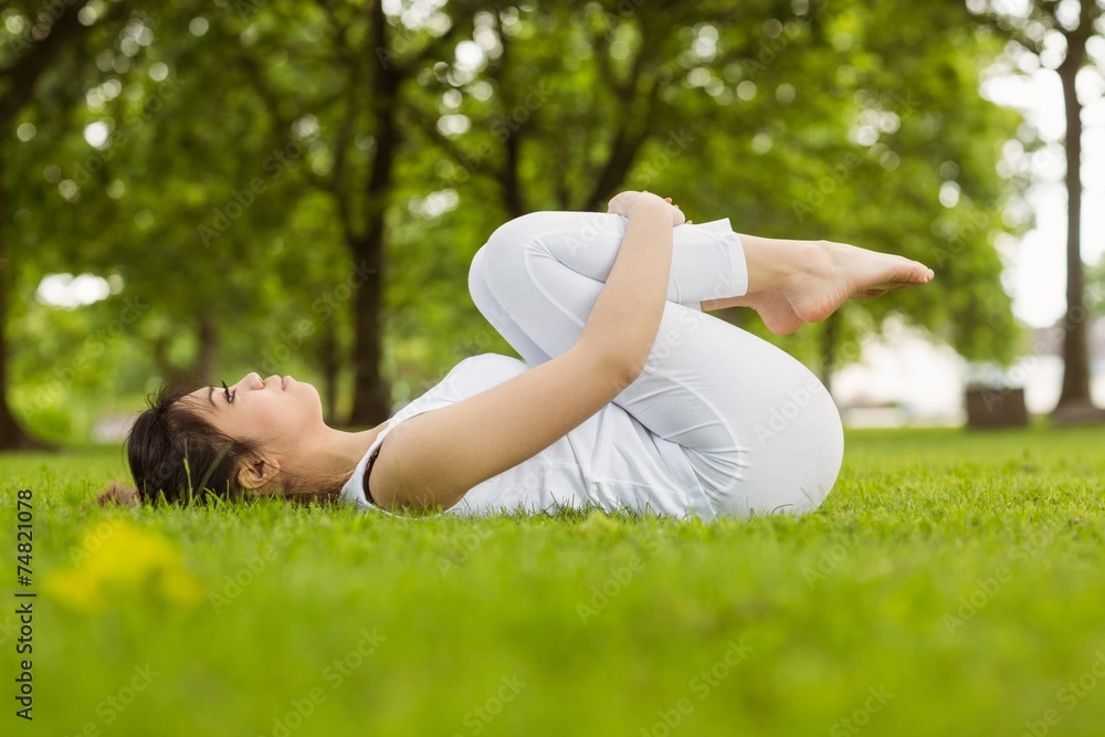 Side view of woman doing stretching exercises in park Side view of woman doing stretching exercises in park