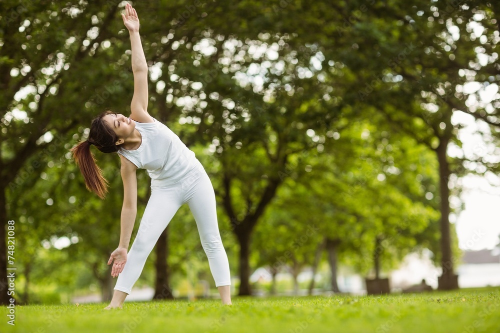 Toned woman doing stretching exercises in park Toned woman doing stretching exercises in park