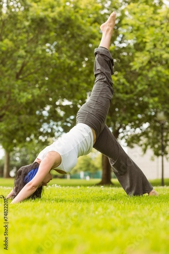 Peaceful brown hair doing yoga on grass