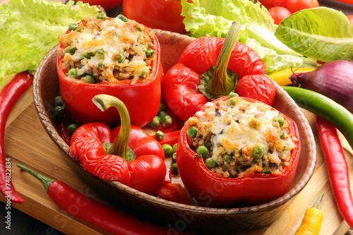Baked peppers stuffed with meat rice and vegetables on cutting b photo