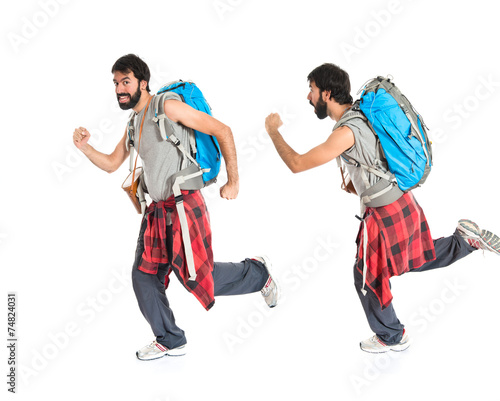 Young backpacker walking over white background