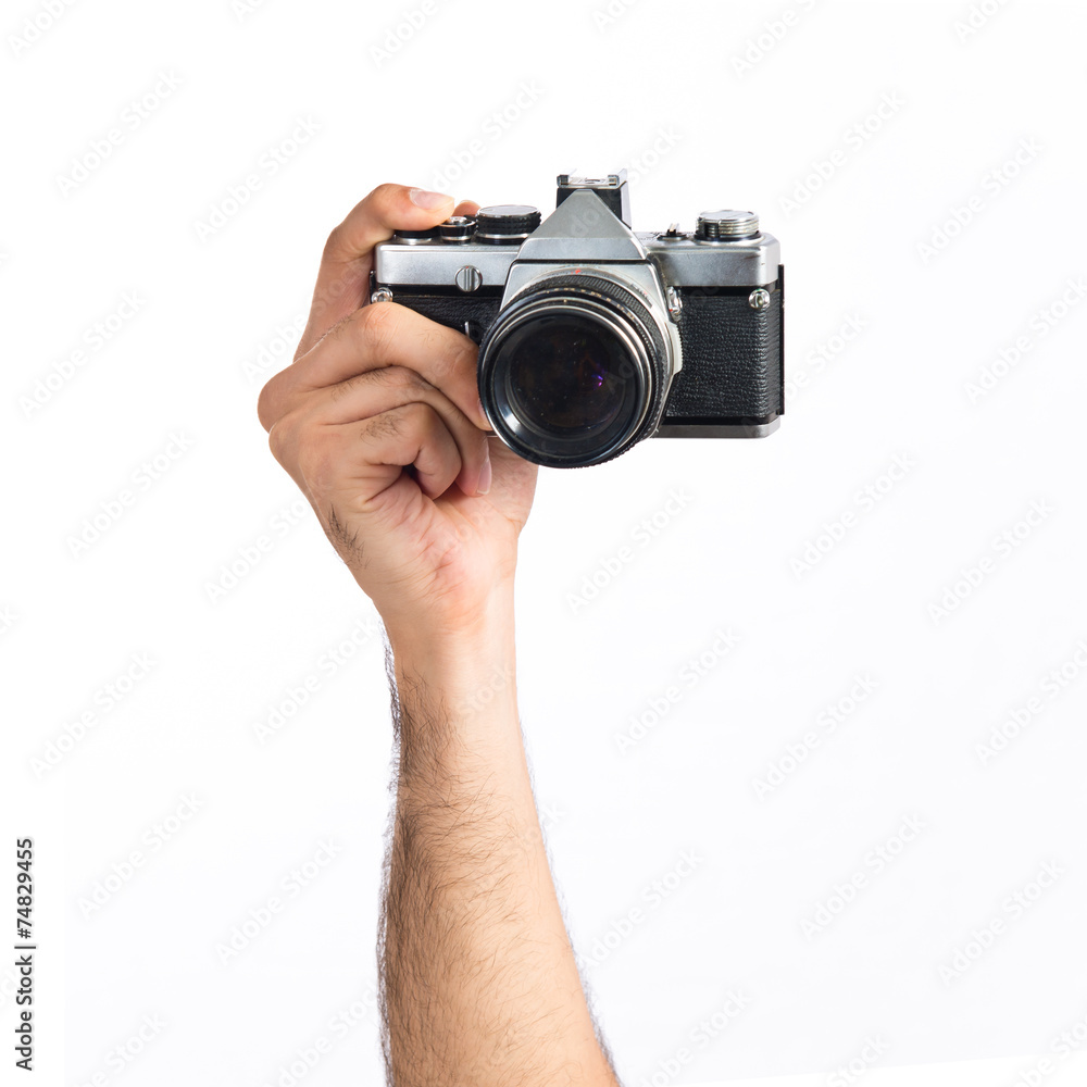 hand holding a camera over white background hand holding a camera over white background