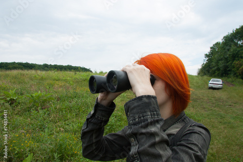 Girl with binocular in field