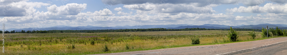 landscape view of the field, clouds and the road