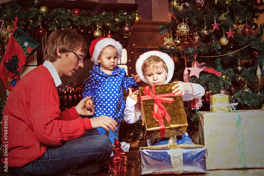 father and kids with presents in christmas