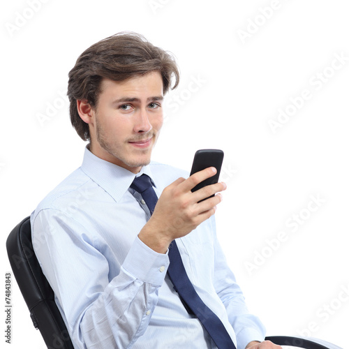 Young businessman sitting on a chair using a smart phone