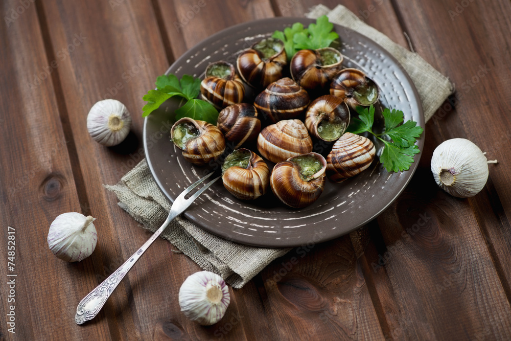 Bourgogne snails with garlic butter, rustic wooden background Bourgogne snails with garlic butter, rustic wooden background